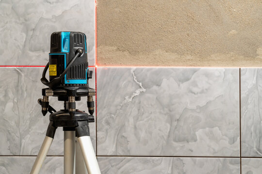 Installation of tiles with a laser level. copy space.