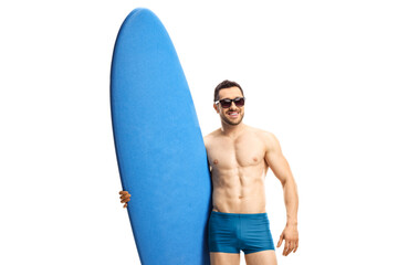 Fit man in swimwear wearing sunglasses and posing with a surfing board