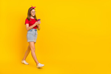 Fototapeta na wymiar Full size photo of traveling little teen girl browsing fast speed in phone search information isolated on yellow color background