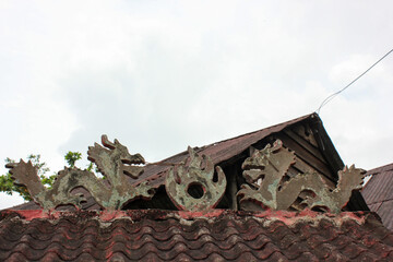 Broken carvings on the roof of an ancient cemetary in the village of Pusing near the town of Ipoh in Malaysia.