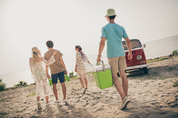 Back full size photo of young funny company go on picnic holiday trip wear trend look by the beach outdoors