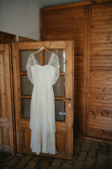 Lace embroidery wedding dress hanging in the room.