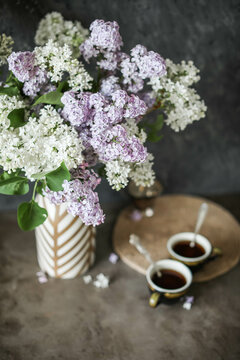 Still life with a lot of lilac flowers and glassware on a dark background. Syringa.. Selective focus