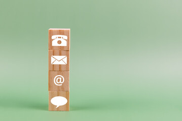 Contact us icon on wood block green background - business concept with copy space