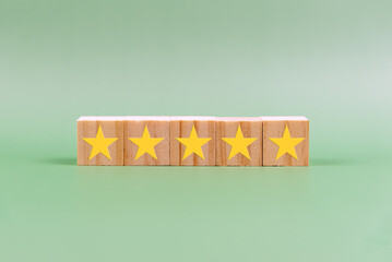 5 star rating on wood block on green background