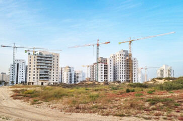 Fototapeta na wymiar City construction among desert dunes. Building yard of Housing construction of houses in new area of the city Holon in Israel