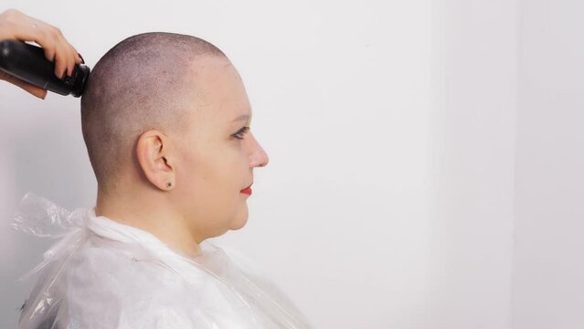 An orthodox Hasidic Jewish woman is shaved bald after her wedding by a hairdresser. medium plan