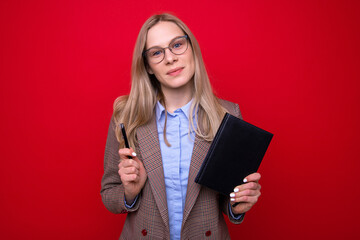 Portrait of a young woman in business clothes with a diary and a pen