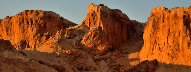 Panoramic view of the red sandstone canyon (quarry) at sunset. Clear blue sky. Atmospheric...