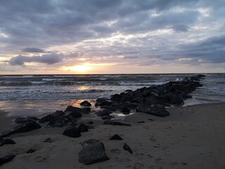 Colorful sunset on the coast of Texel, near a breakwater.