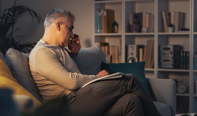 Fototapeta premium Man relaxing on the couch and reading