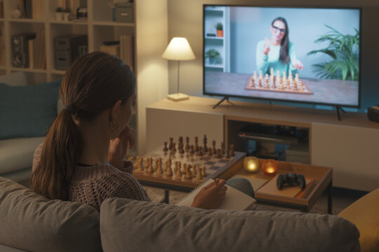 Woman learning chess on TV
