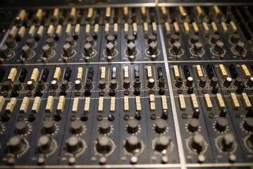Close-up of mixing console panel in sound recording studio. Audio desk background. Creating music concept