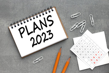 plans 2023. text on an open notebook near the calendar