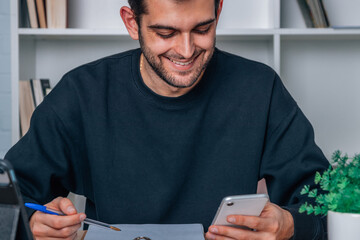 man at home or office working at desk with mobile phone