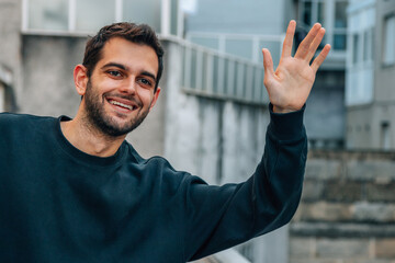 smiling young man on the street hailing a taxi on the street