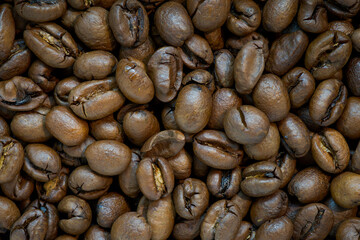 Whole roasted coffee beans. Detail on the beans, no background. Macro shot.