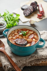 Asturiana traditional fabada with haricot, blood sausage on brown background. Vertical orientation....