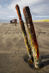 skeleton shipwreck rusting on the beach buried in sand