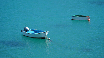 Two Colourful small boats moored in harbour.