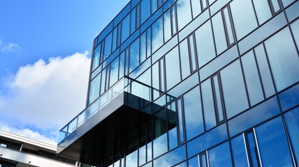 Modern office building with glass facade on a clear sky background. Abstract close up of the glass-clad facade of a modern building covered in reflective plate glass.