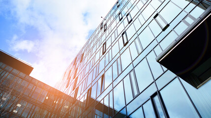 Modern office building with glass facade on a clear sky background. Abstract close up of the glass-clad facade of a modern building covered in reflective plate glass.