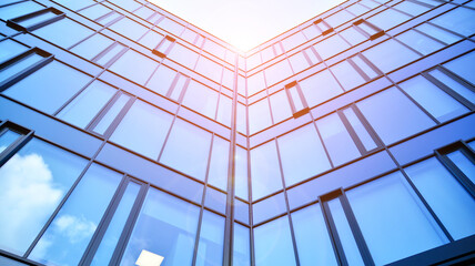 Modern office building with glass facade on a clear sky background. Abstract close up of the glass-clad facade of a modern building covered in reflective plate glass.