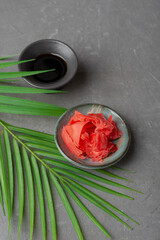 Pickled red ginger for sushi and rolls on a black background in a bowl