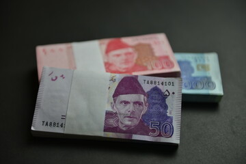 Stacks of Pakistan Rupee in different denominations. Currency war concept, Falling Rupee value in Pakistan against US Dollar. Shallow depth of field. Selective focus.