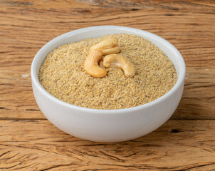 Cashew nut flour in a bowl over wooden table. Gluten free flour