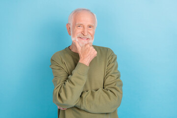 Portrait of attractive cheerful content grey-haired man touching chin thinking isolated over bright blue color background