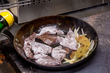 Cook roasts calf liver with onion and bay leaf