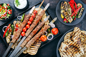 Traditional Turk Adana kebap on shashlik skewer with barbecue vegetable and flatbread served as top...