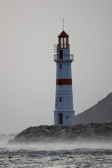 Lighthouse among the rising waves of a storm in Lodos. Turgutreis, Bodrum.