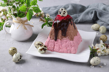 Easter Orthodox Curd dessert with cherries and chocolate, decorated with quail eggs on gray background. Spring still life