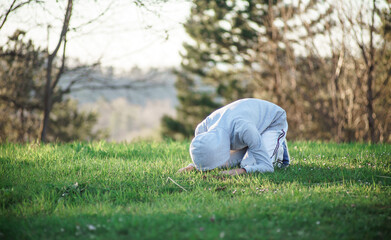 Fototapeta na wymiar Muslim young man prays outdoor, the holy month of Ramadan