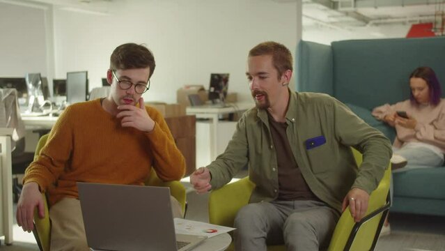 Two handsome young students are representing their paper project to the professor on the video call