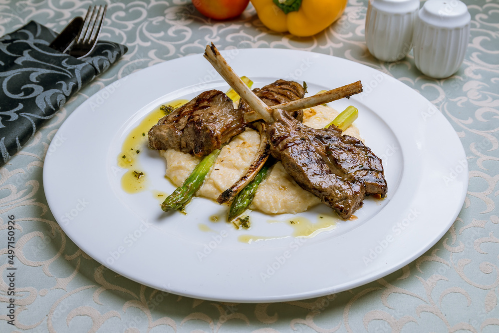 Wall mural Rack of lamb with mashed potatoes and asparagus on white plate