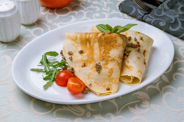 pancakes with meat and tomato on white plate