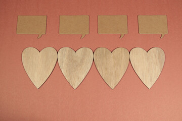 Four speech bubbles each above a wooden heart
