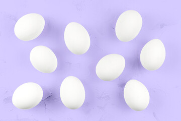 White eggs on a purple textured background.