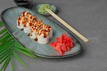Uramaki rolls with red fish and garnish on a gray background
