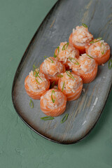 Uramaki rolls with red fish and garnish on a gray background