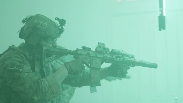 Men walking down corridor lit by flashes. Side view of people in camouflage uniform with rifles playing airsoft military game in building, searching for enemy. Airsoft game, indoor activity concept
