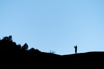 silhouette of a person standing on a rock