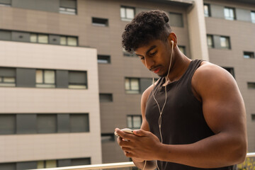 Fototapeta na wymiar Arab strong young man doing sport in the city, preparing the music before training