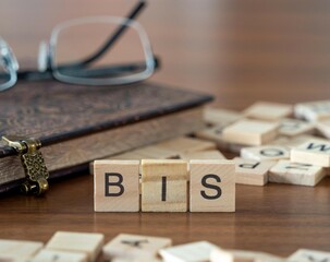 the acronym bis for Bank for International Settlements word or concept represented by wooden letter tiles on a wooden table with glasses and a book