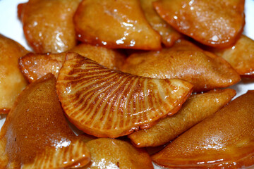 Qatayef dumplings stuffed and filled with nuts and shredded coconuts fried in deep oil and soaked...
