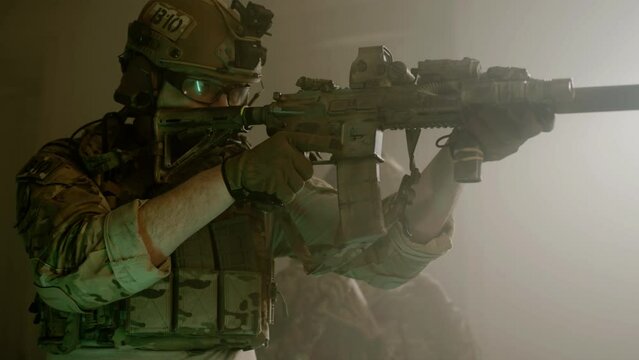 Focused soldiers in camouflage uniform taking sight. Side view of men in safety glasses and helmets getting ready for airsoft military game in dark building. Battle, military, operation concept