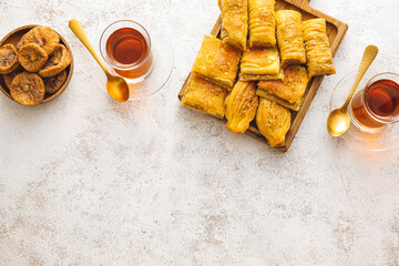 Tasty Eastern sweets and tea on grunge background